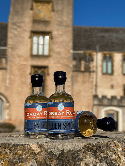 3 mini bottles of golden spiced rum in front of torre abbey